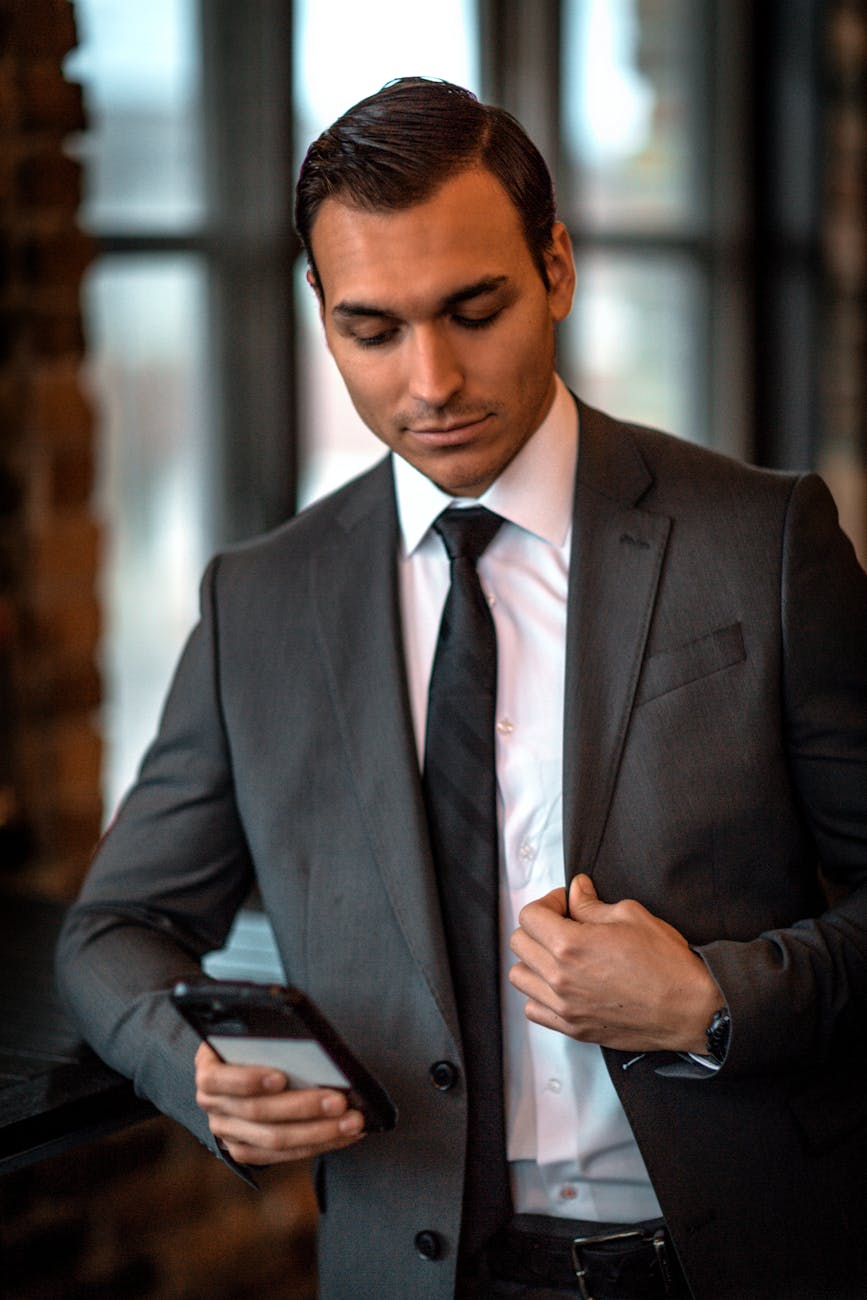a handsome man in suit using a smartphone