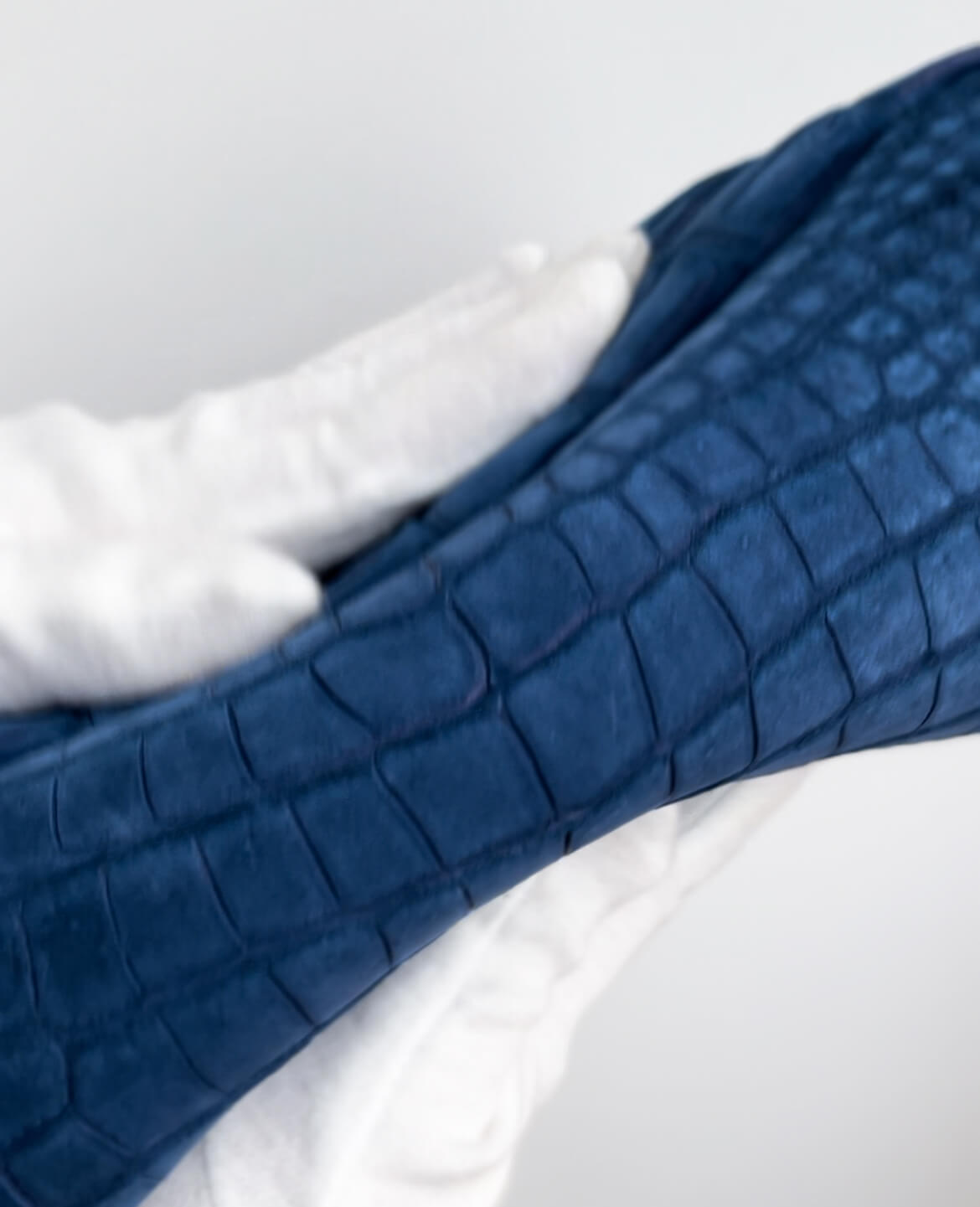 日本ブランド「レザック」のセカンドバッグ。希少なヌバッククロコダイルの一枚革を贅沢に使った銀座HIKO限定品、色は青。柔らかさを示す写真