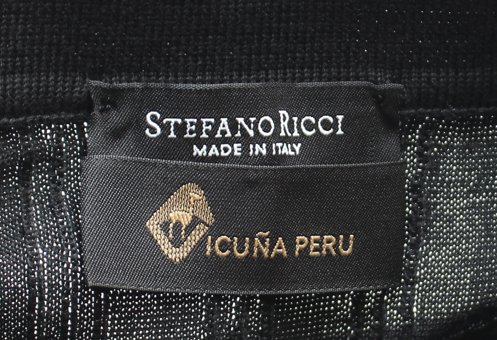 ヴィキューナを混ぜたコットン素材の、黒い半そでポロセーター(イタリア高級メンズブランド ステファノリッチ製)につけられた「ヴィキューナ」の証となるラベルの拡大写真