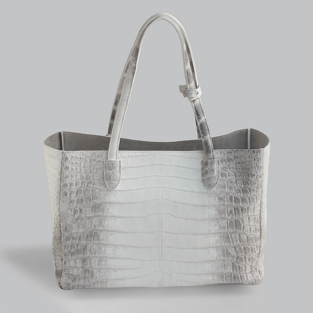 日本が誇るエキゾチックレザー専門ブランド レザックによる、希少なヒマラヤクロコダイルの一枚革をぜいたくに使った40cm幅の横長トートバッグを真正面から映した写真