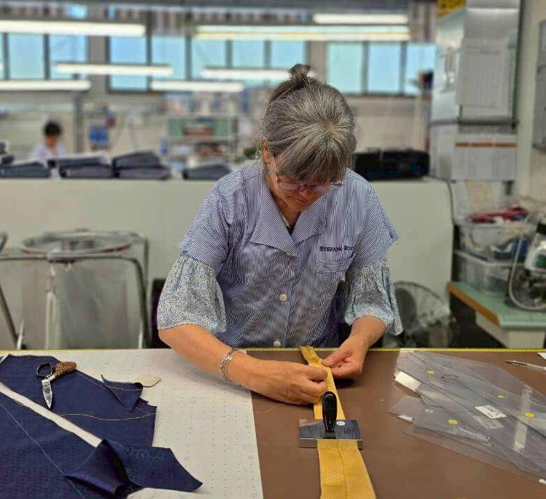 銀座HIKOバイヤーの佐藤がイタリアのステファノリッチ本社工場で撮影したネクタイを手縫いしている現場の写真