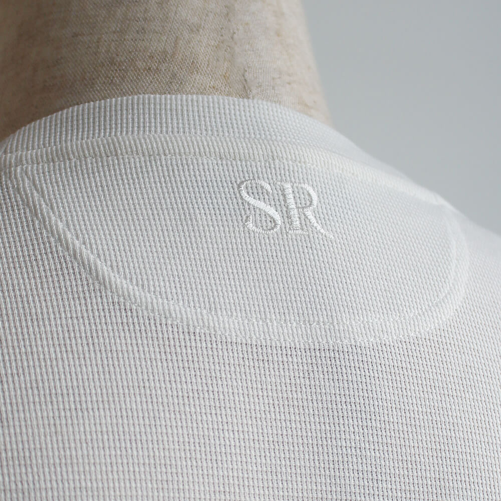 ステファノリッチの白いTシャツに入っているSRの刺繍の拡大写真。首の下(背中側)あたりに刺繍されている